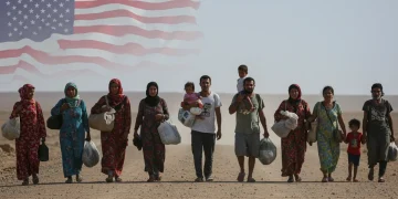 Refugees on a dusty road, representing the global displacement crisis and the need for humanitarian aid.